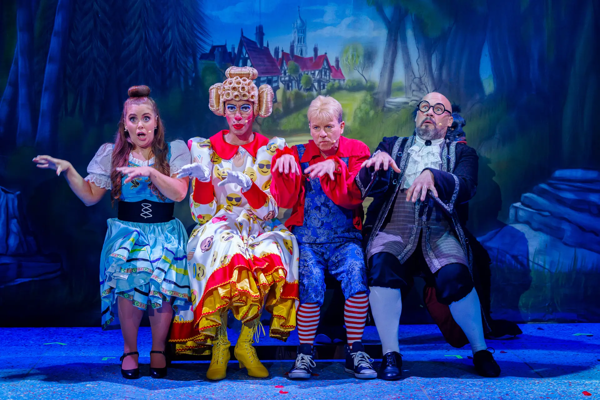 Four brightly costumed characters from the Beauty and the Beast pantomime performing on stage at the Marina Theatre in Lowestoft, with exaggerated expressions and gestures. Captured by Theatre photography specialist, Fourth Wall Photography.