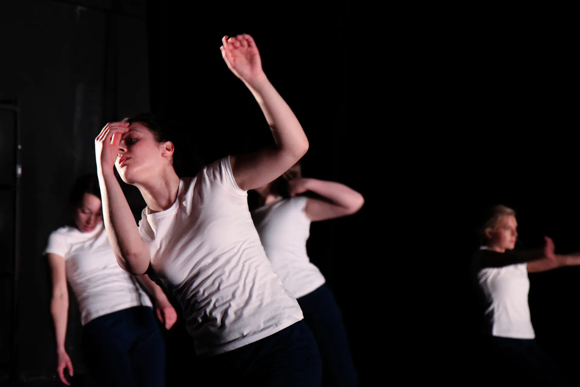 Dancers mid-movement on stage in Lead The Way, a dance performance by True Motion Dance at the Green Room in Manchester. Side lit with warm lighting. Captured by Dance photography specialist, Fourth Wall Photography.