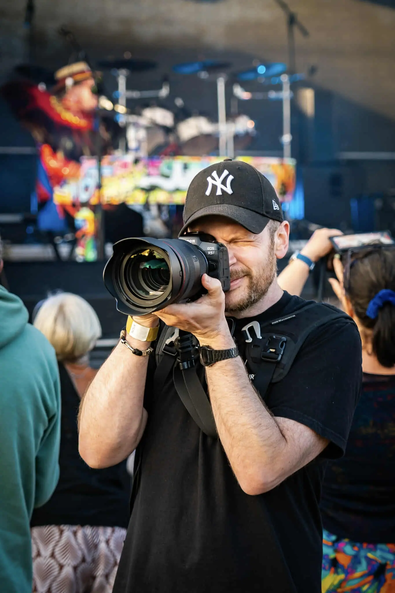 Matt Coomber-Such founder and photographer at Fourth Wall Photography holding a camera and capturing a live performance at the Legends Festival in Cromer