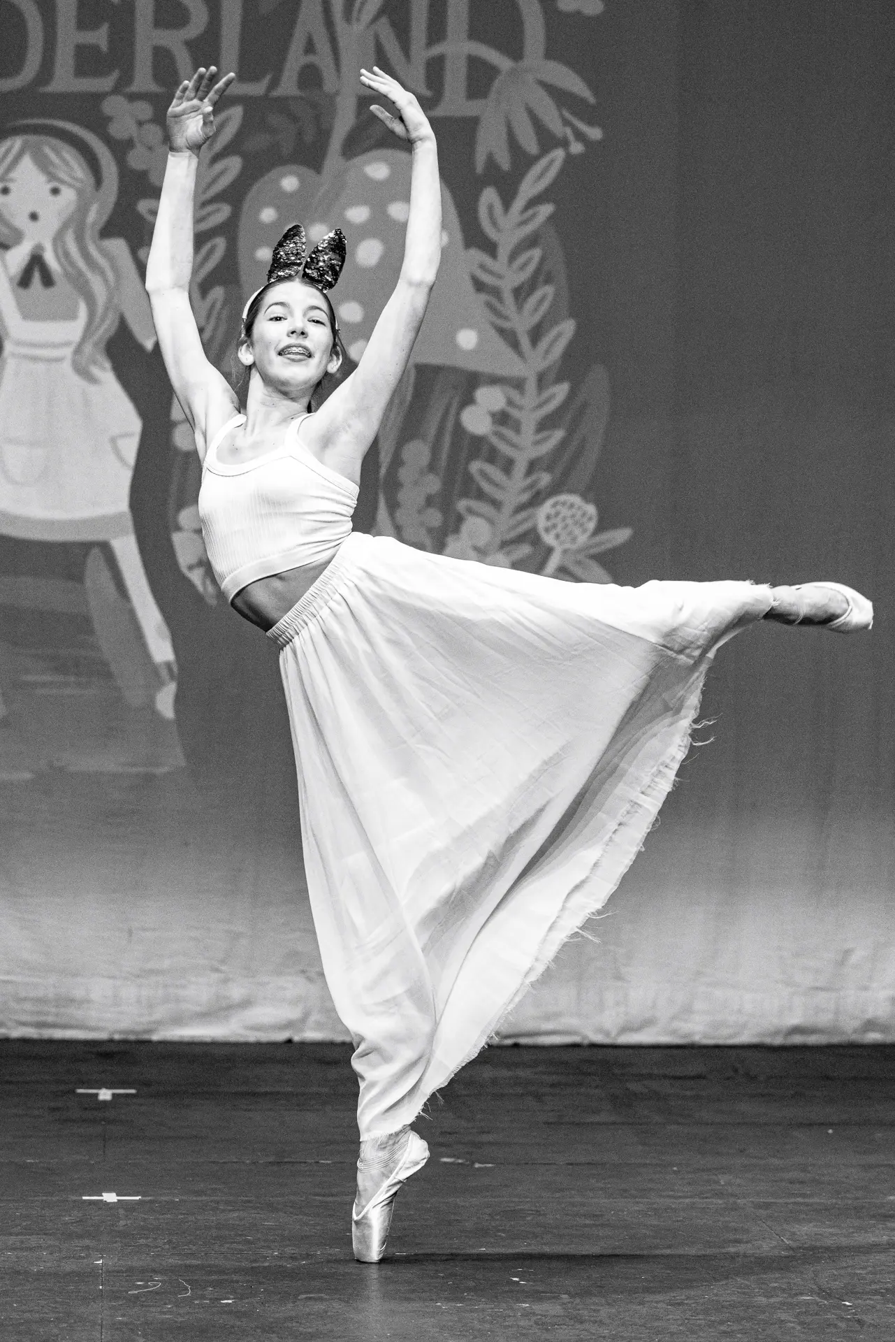 Young dancer performing a ballet routine at the Schools Dance Festival at the Marina Theatre Lowestoft. Captured mid‑movement on stage with vibrant lighting. Captured by Dance photography specialist, Fourth Wall Photography.