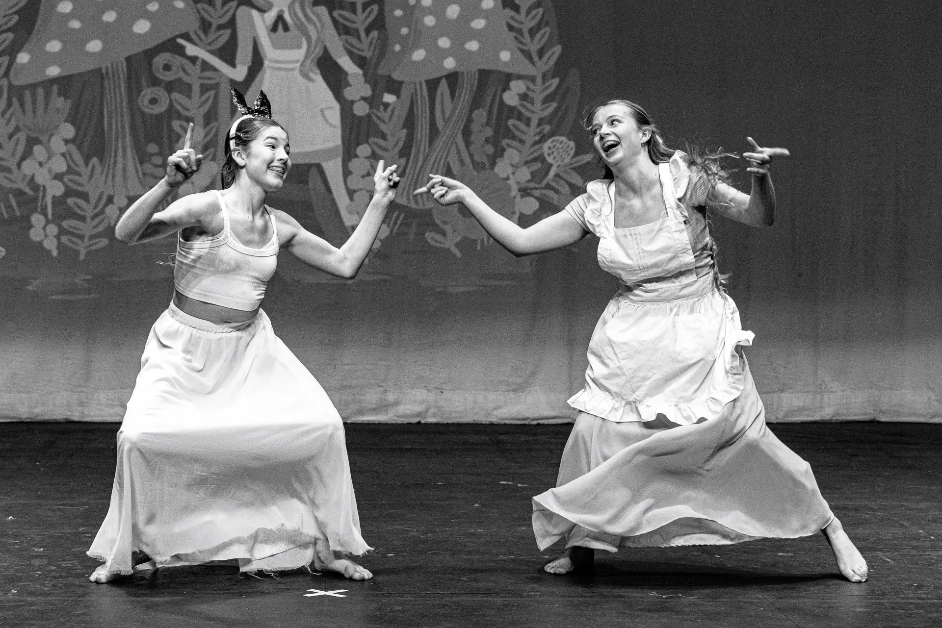 Young dancers performing a contemporary dance routine at the Schools Dance Festival at the Marina Theatre Lowestoft. Captured mid‑movement on stage with vibrant lighting. Captured by Dance photography specialist, Fourth Wall Photography.