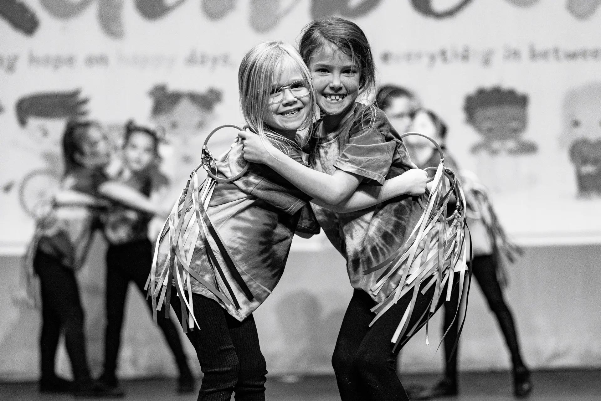Young dancers performing a musical theatre routine at the Schools Dance Festival at the Marina Theatre Lowestoft. Captured mid‑movement on stage with vibrant lighting. Captured by Dance photography specialist, Fourth Wall Photography.