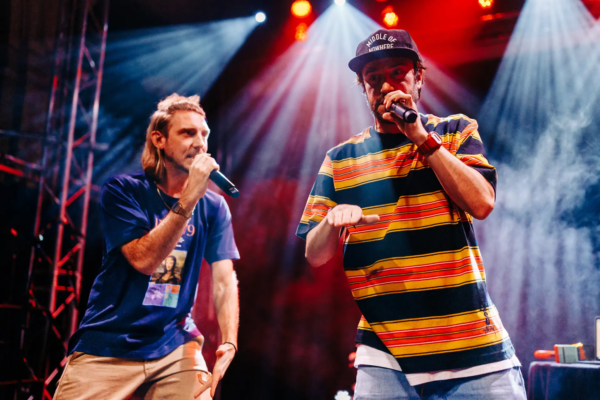 Rap duo Too Many T's performing live on stage at Norwich Arts Centre, rapping into microphones under stage lights and smoke. Captured by Live Music photography specialist, Fourth Wall Photography.