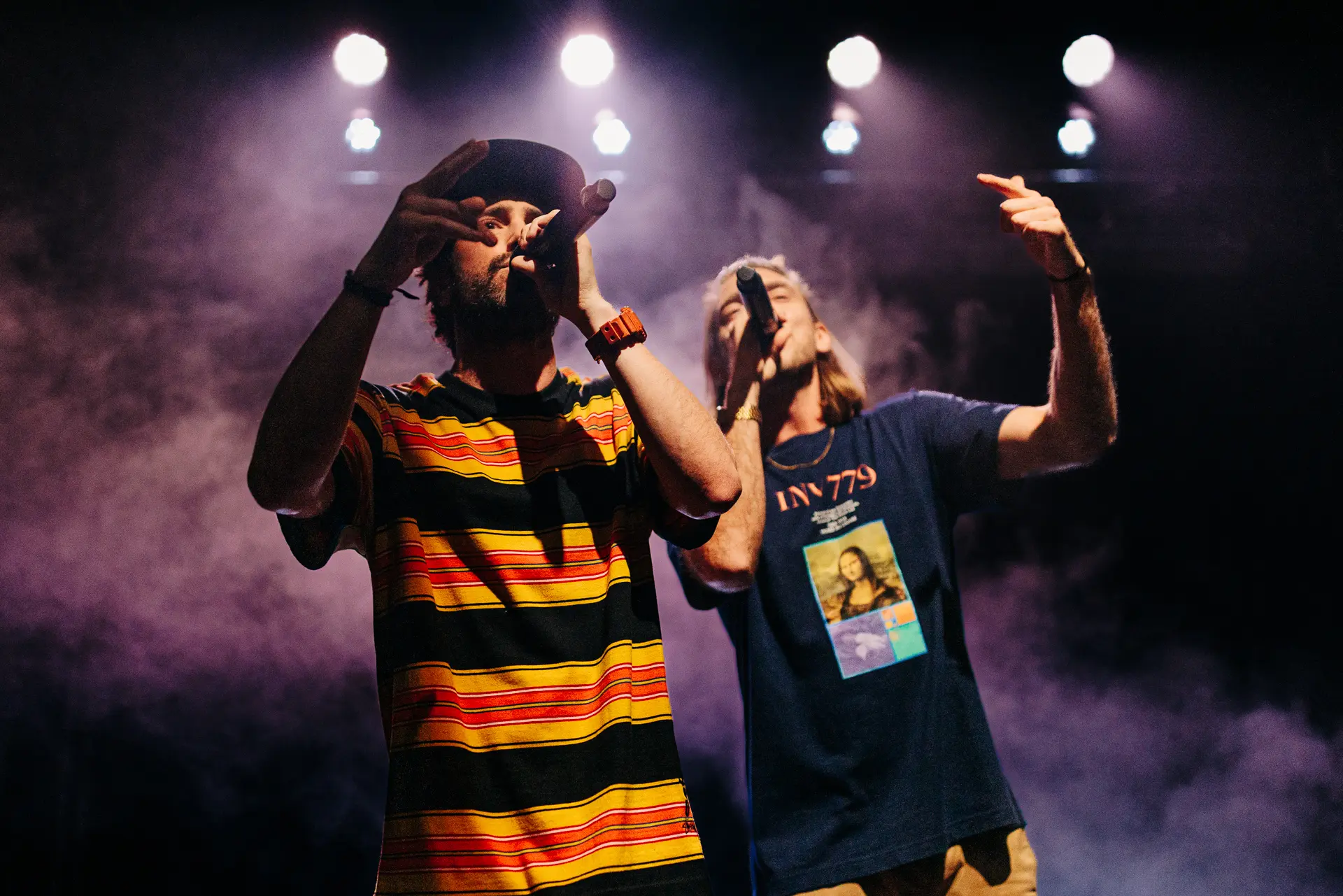 Rap duo Too Many T's performing live on stage at Norwich Arts Centre, rapping into microphones under stage lights and smoke. Captured by Live Music photography specialist, Fourth Wall Photography.