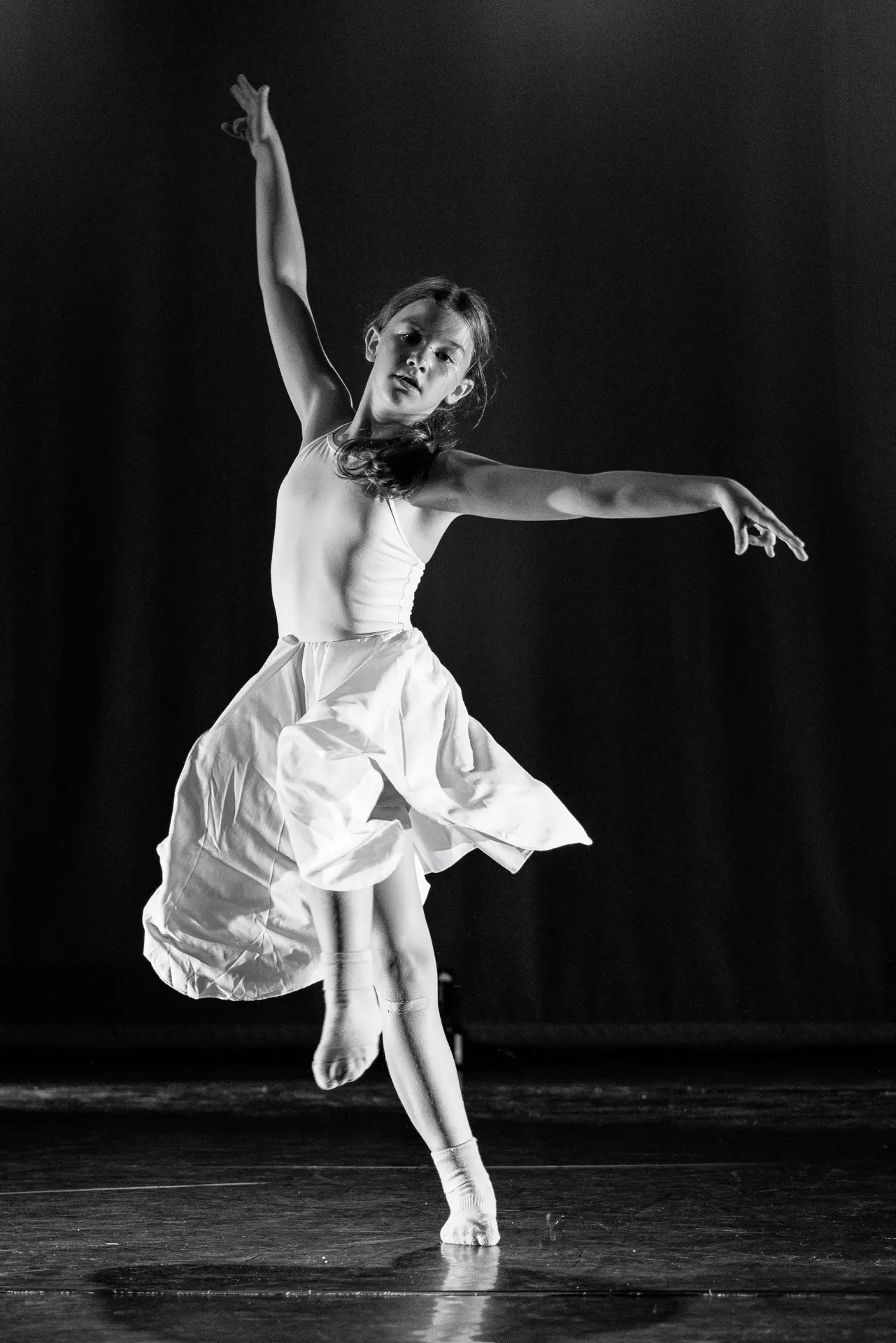 Dancer performing a contemporary dance solo routine on stage at the True Motion Dance Showcase at the Atrium Theatre in Norfolk, captured mid‑movement with expressive choreography and dynamic lighting. Captured by Dance photography specialist, Fourth Wall Photography.