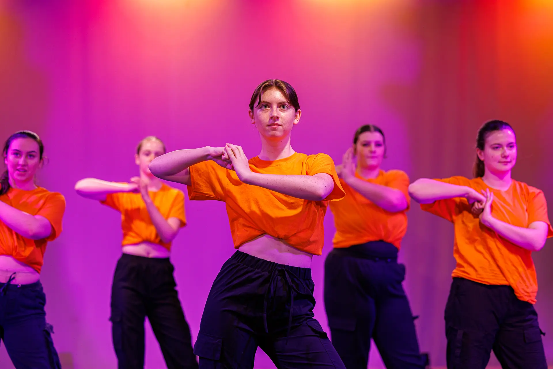 Dancer performing a street dance routine on stage at the True Motion Dance Showcase at the Atrium Theatre in Norfolk, captured mid‑movement with expressive choreography and dynamic lighting.