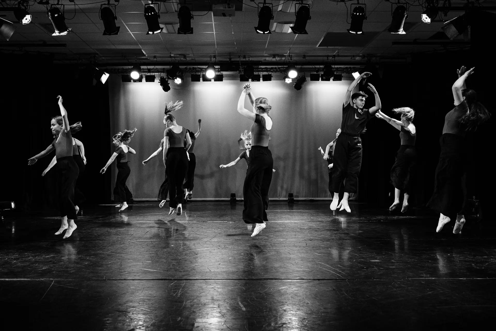 Dancers performing a contemporary dance routine on stage at the True Motion Dance Showcase at the Atrium Theatre in Norfolk, captured mid‑movement with expressive choreography and dynamic lighting. Captured by Dance photography specialist, Fourth Wall Photography.