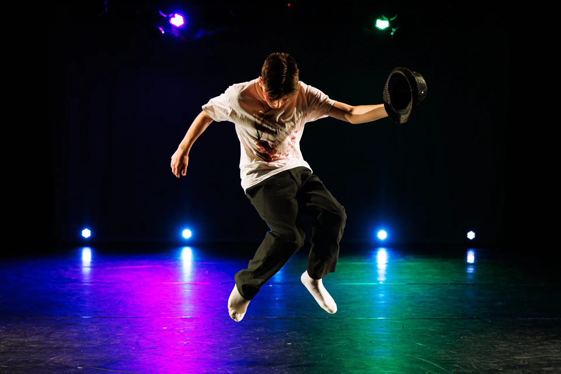 Dancer performing a street dance routine on stage at the True Motion Dance Showcase at the Atrium Theatre in Norfolk, captured mid‑movement with expressive choreography and dynamic lighting. Captured by Dance photography specialist, Fourth Wall Photography.