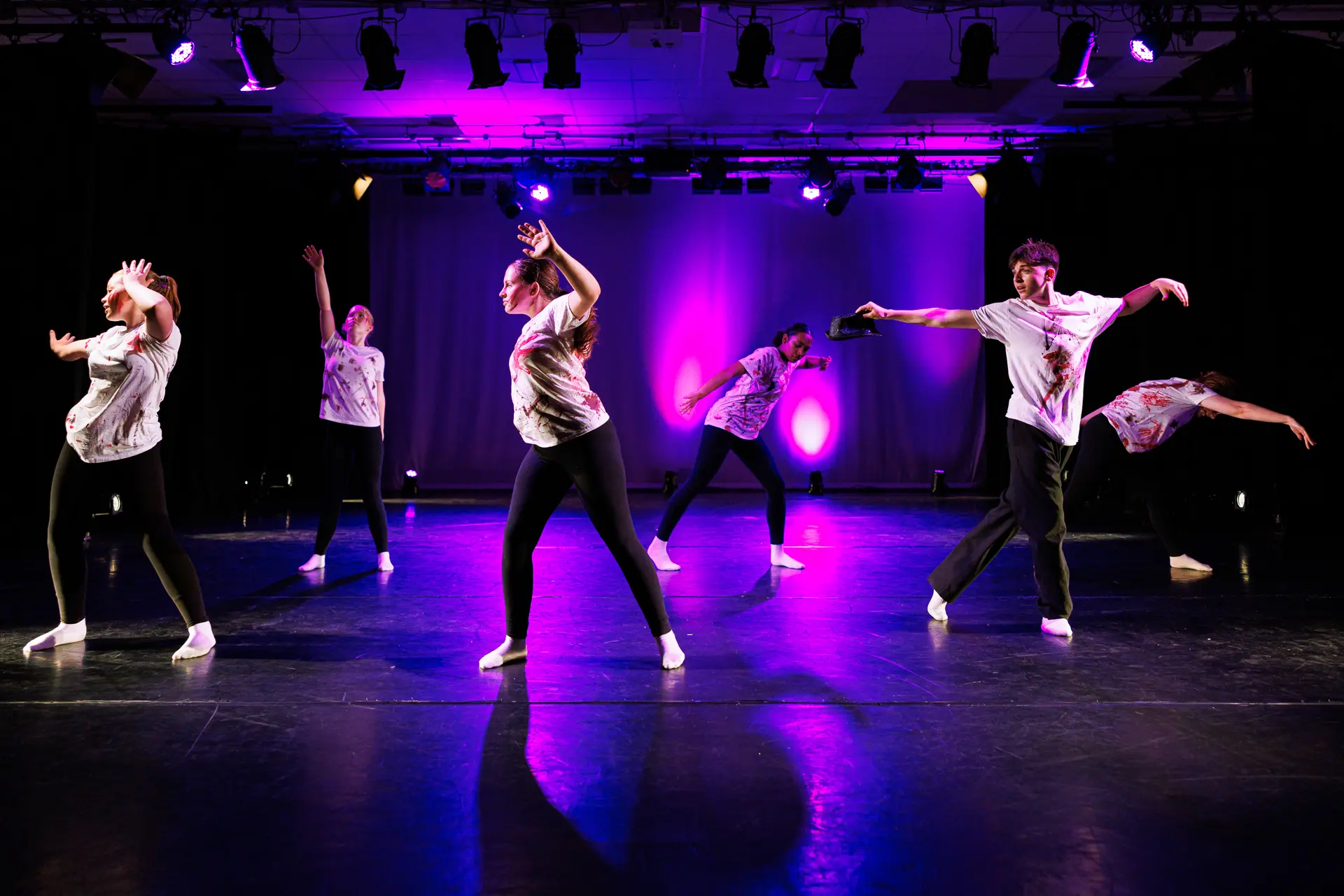Dancers performing a street dance routine on stage at the True Motion Dance Showcase at the Atrium Theatre in Norfolk, captured mid‑movement with expressive choreography and dynamic lighting. Captured by Dance photography specialist, Fourth Wall Photography.