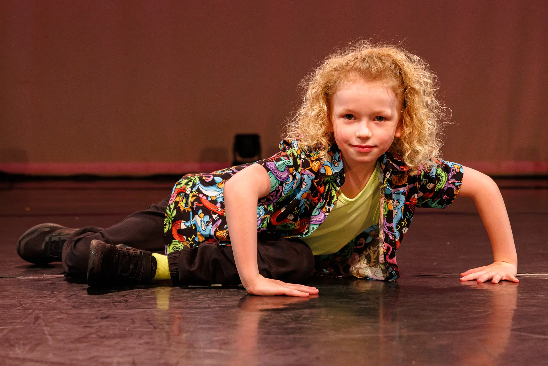 Dancer performing a street dance routine on stage at the True Motion Dance Showcase at the Atrium Theatre in Norfolk, captured mid‑movement with expressive choreography and dynamic lighting. Captured by Dance photography specialist, Fourth Wall Photography.
