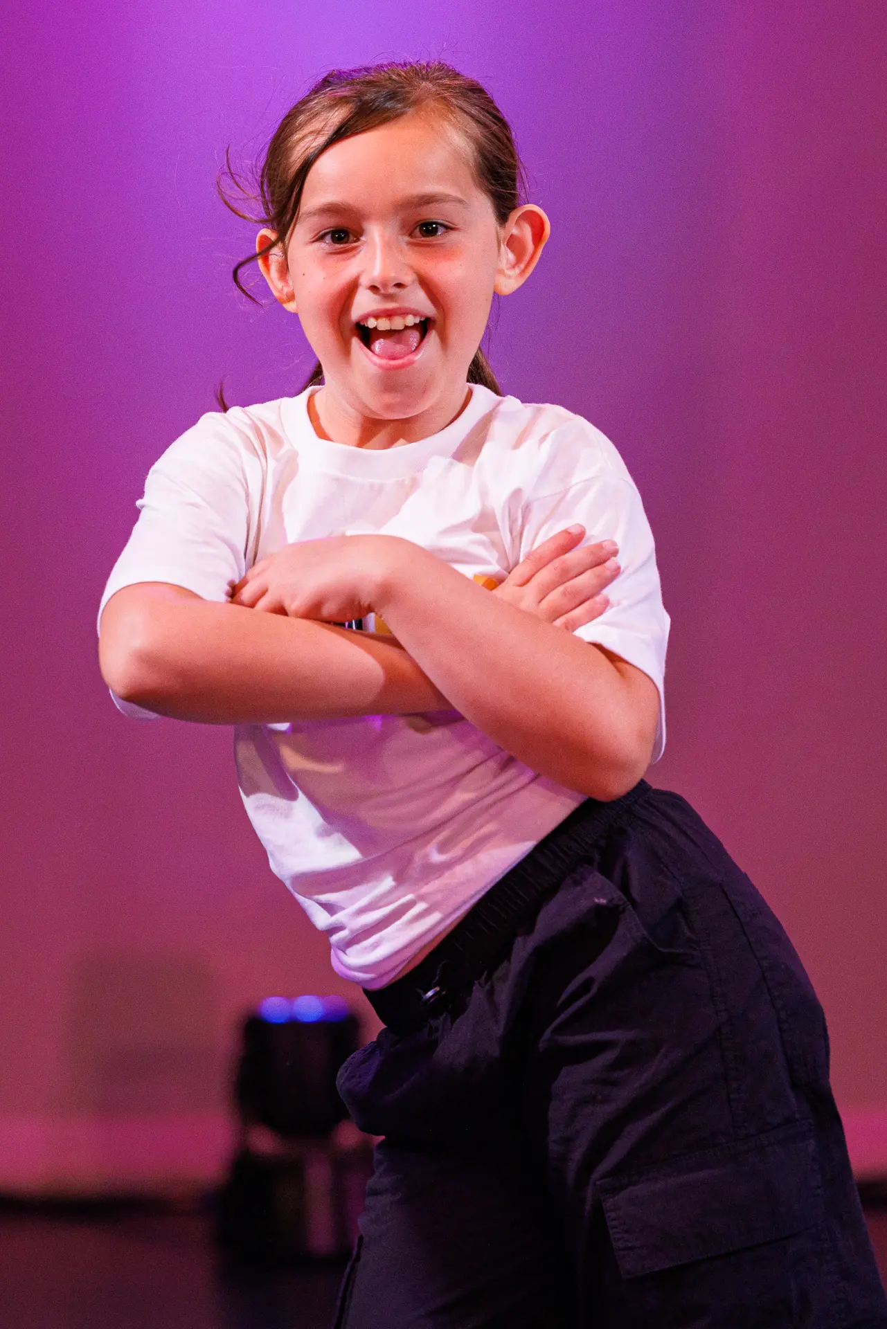 Dancer performing a street dance routine on stage at the True Motion Dance Showcase at the Atrium Theatre in Norfolk, captured mid‑movement with expressive choreography and dynamic lighting. Captured by Dance photography specialist, Fourth Wall Photography.